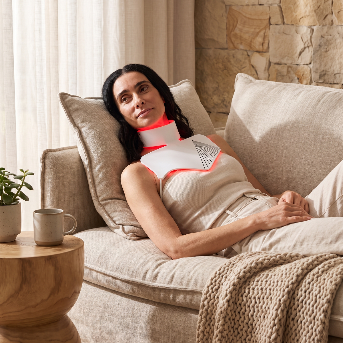 Omnitality NeckLume LED Neck and Décolletage Mask being used while relaxing on a couch at home